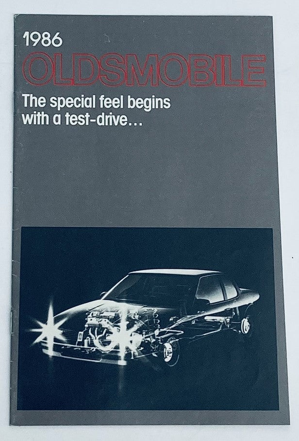 1986 Oldsmobile Lineup Dealer Showroom Sales Brochure Guide Catalog cover featuring a graphic of a car, emphasizing the slogan 'The special feel begins with a test-drive...'