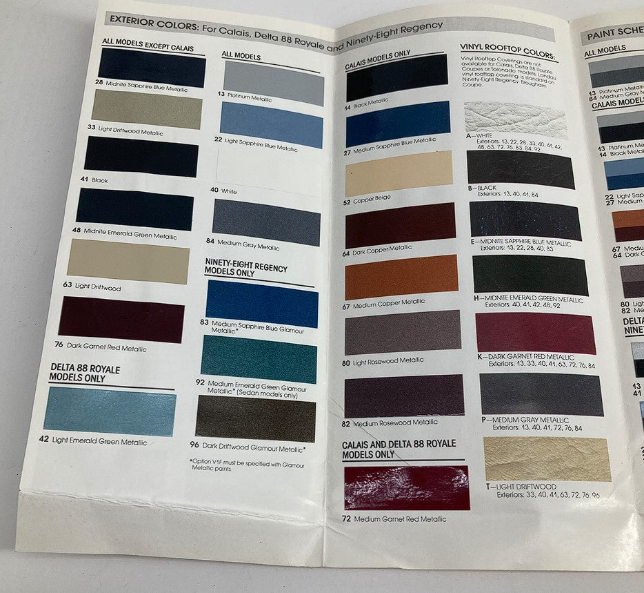 1987 Oldsmobile Color Chip & Fabric Folder Dealer Sale Brochure Guide Catalog showcasing exterior color options for Calais, Delta 88 Royale, and Ninety-Eight Regency models, including various color swatches and descriptions.
