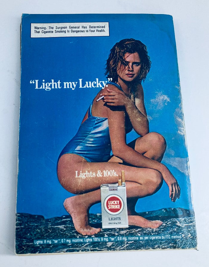 Back cover of a vintage magazine featuring a model in a blue swimsuit promoting Lucky Strike cigarettes with the slogan 'Light my Lucky,' from the 1980s.