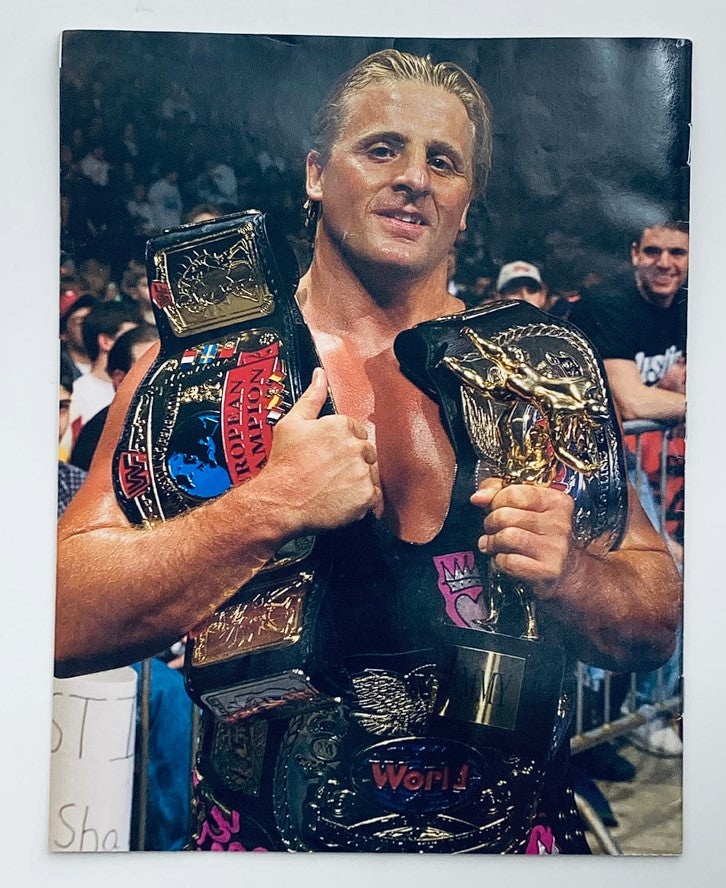 WWF World Wrestling Federation Magazine Owen Hart Tribute 1965-1999 cover featuring Owen Hart holding multiple championship belts, showcasing his iconic wrestling legacy. The photo captures the emotional essence of the tribute issue honoring his life and contributions to professional wrestling.