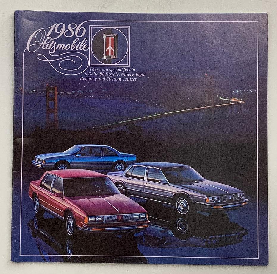 1986 Oldsmobile Delta 88 Royale Dealer Showroom Sales Brochure cover featuring the Delta 88 Royale and other models against a twilight backdrop with the Golden Gate Bridge.
