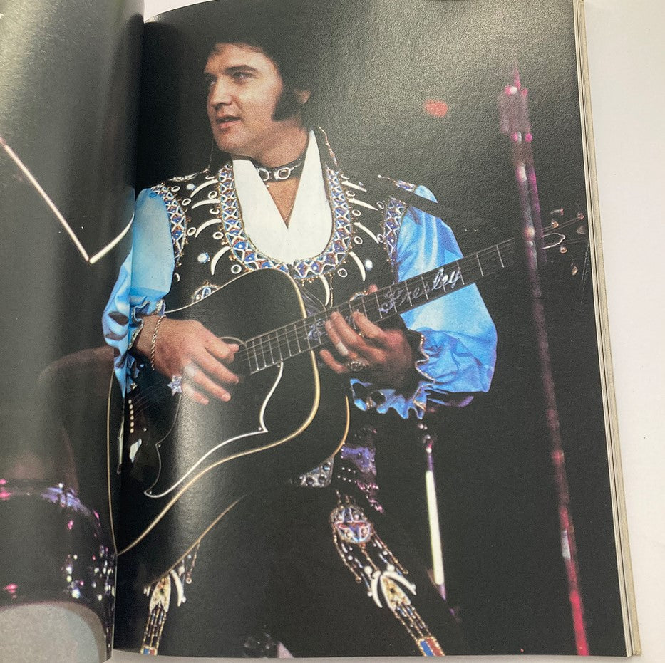 Vintage 1979 Elvis in Concert by John Reggero A Delta Special featuring Elvis Presley performing on stage with an acoustic guitar, dressed in a flamboyant outfit.