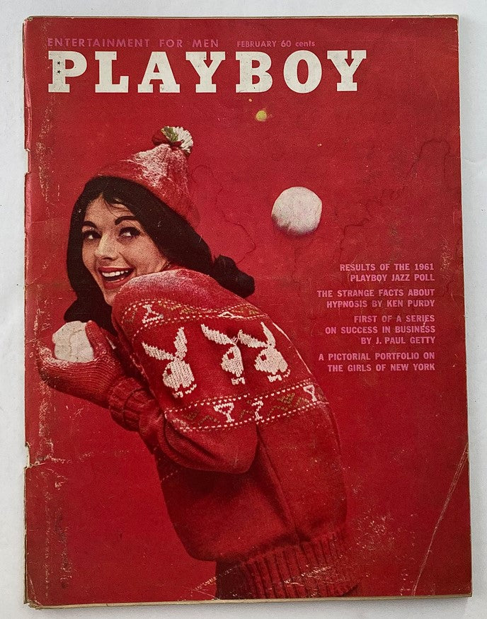 Cover of Playboy Magazine February 1961 featuring a woman in a festive red sweater with snowballs, embodying the charm of vintage magazine culture.