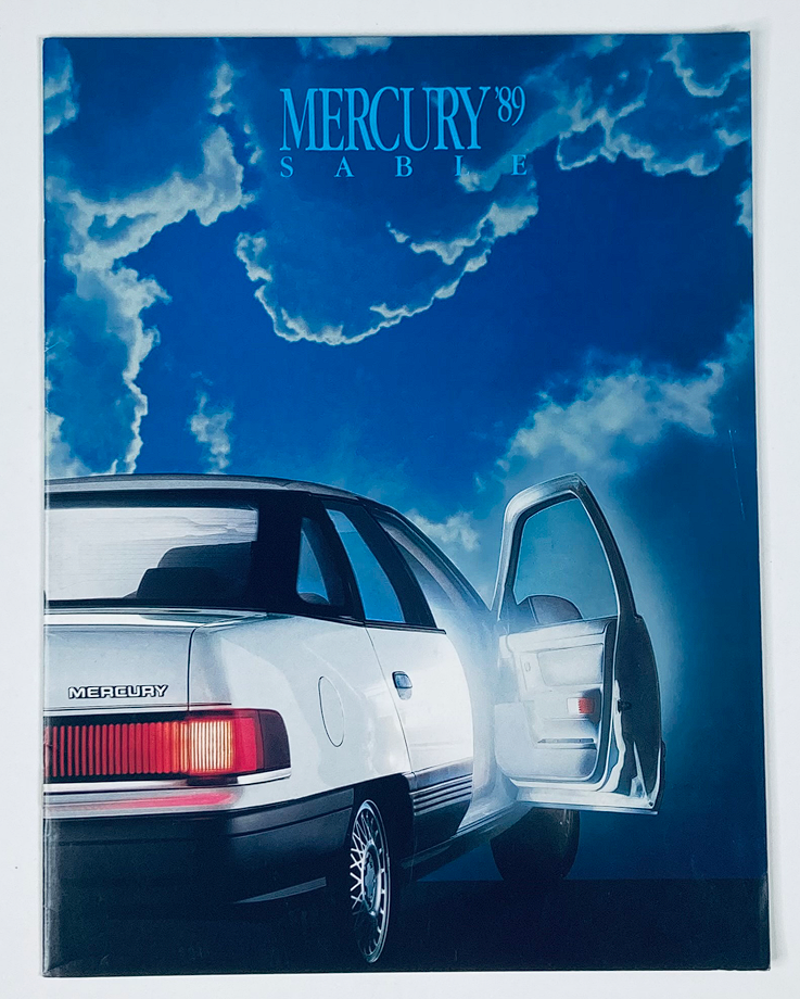 1989 Mercury Sable Dealer Showroom Sales Brochure Guide Catalog featuring a striking image of a Mercury Sable car parked with an open door against a dramatic blue sky backdrop.