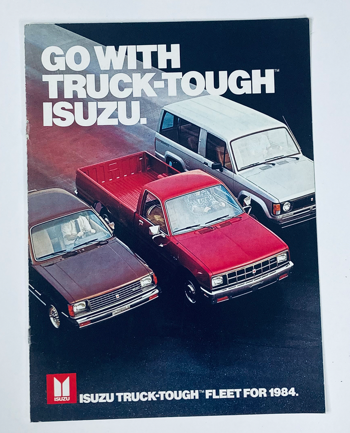 1984 Isuzu Truck Dealer Showroom Sales Brochure showcasing three Isuzu vehicles, emphasizing the 'Truck-Tough' quality for the 1984 fleet.