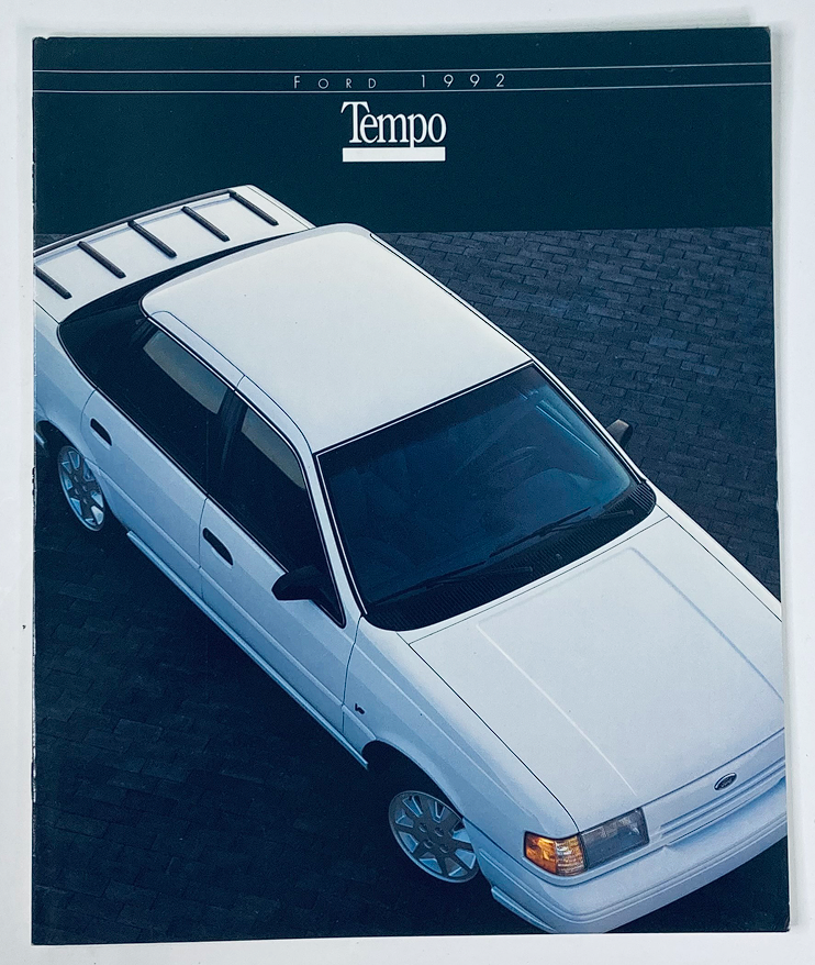 1992 Ford Tempo Dealer Showroom Sales Brochure Guide Catalog featuring an aerial view of a white Ford Tempo parked on a cobblestone surface.