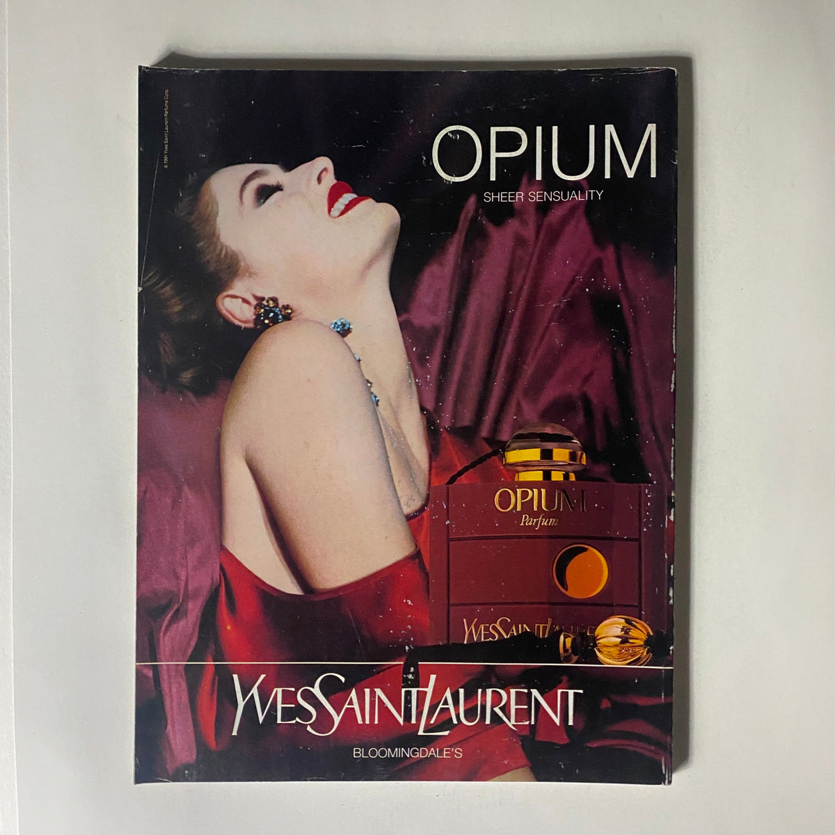 Cover of an advertisement for Yves Saint Laurent's Opium perfume featured in Vogue Magazine January 1992, showcasing luxurious branding and glamorous imagery.