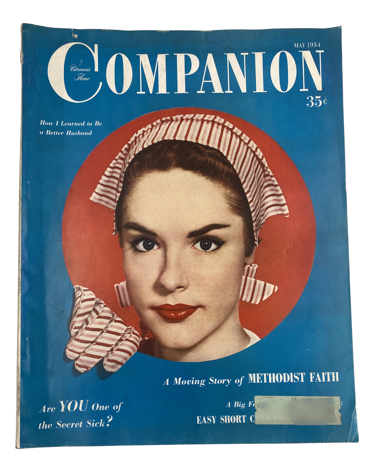 Cover of Woman’s Home Companion Magazine May 1954 featuring a woman with a washing machine hat and matching gloves, highlighting the theme of 'How I Learned to Be a Better Husband' and 'A Moving Story of Methodist Faith.'