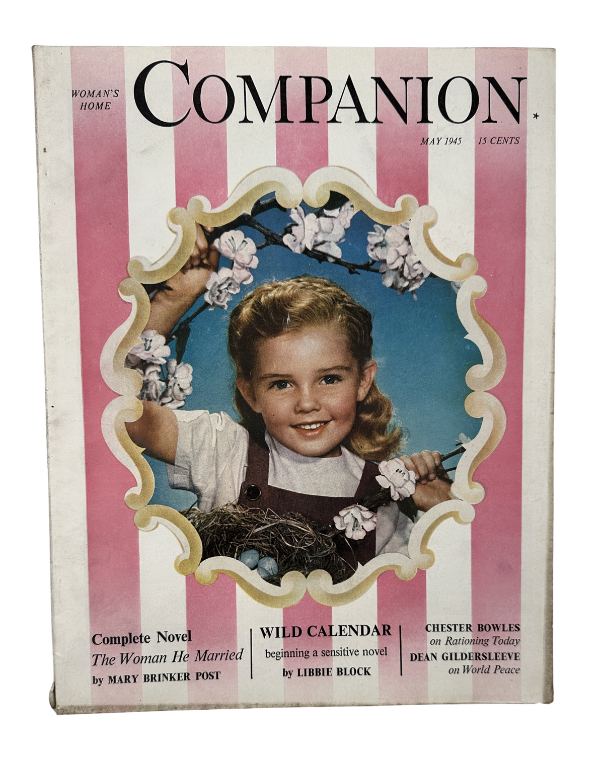 Cover of Woman’s Home Companion Magazine May 1945 featuring Luana Patten, highlighting the complete novel 'The Woman He Married' and the article 'Wild Calendar' by Libbie Block, with a vintage design and a young girl in a floral setting.