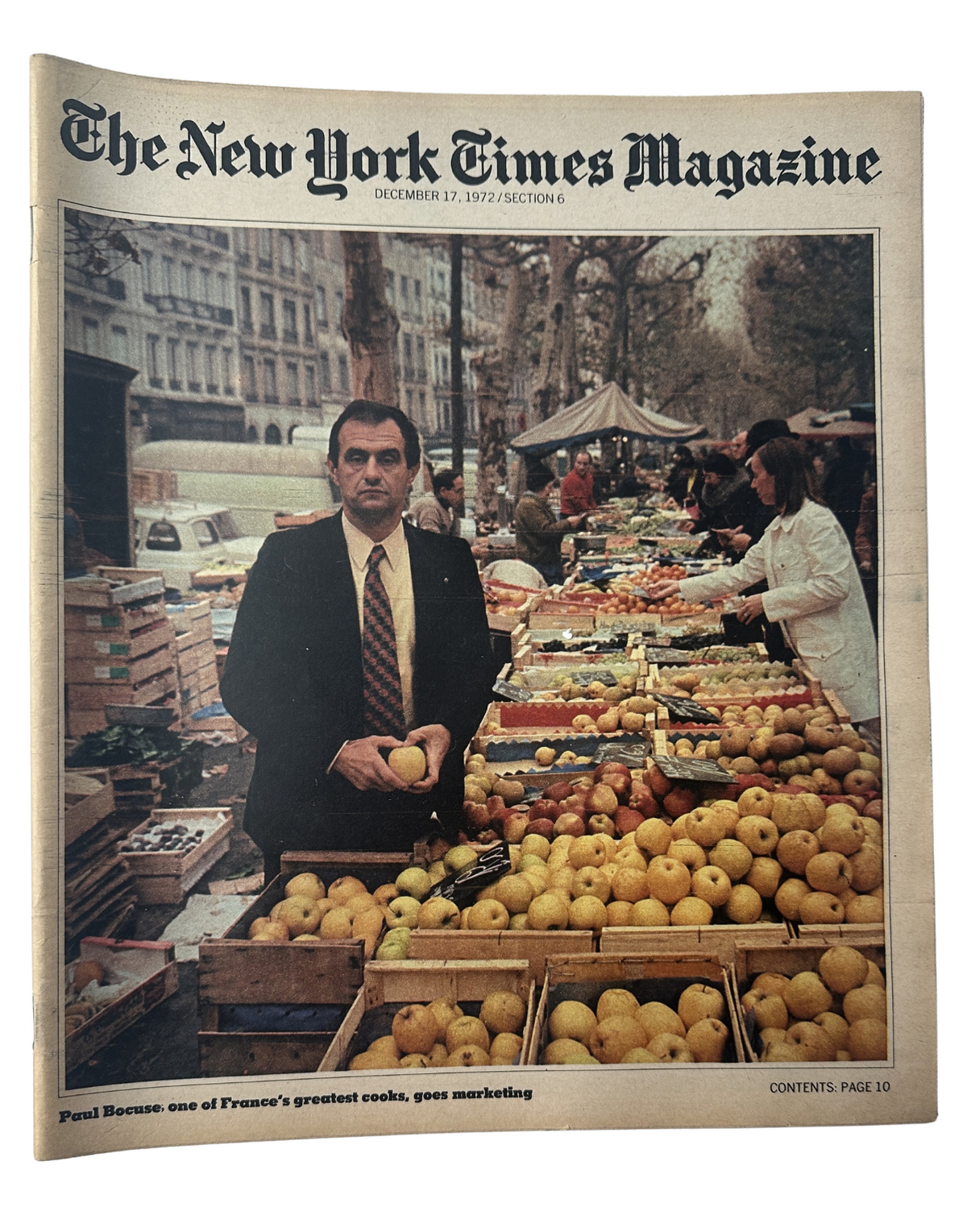 The New York Times Magazine cover from December 17, 1972, featuring Paul Bocuse, a renowned French chef, standing in front of a vibrant outdoor market with a variety of apples. This issue highlights Bocuse's influence on French cooking and its marketing.