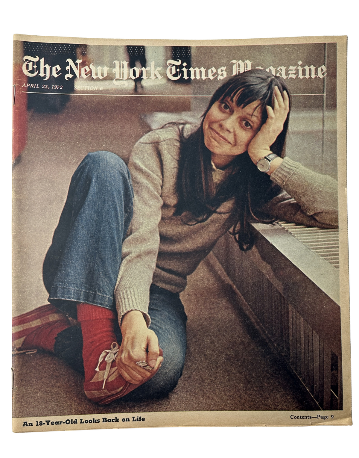 The New York Times Magazine April 23, 1972 featuring Joyce Maynard on the cover, capturing her thoughtful expression as she sits, with a playful posture, wearing a cozy sweater and vibrant red shoes.