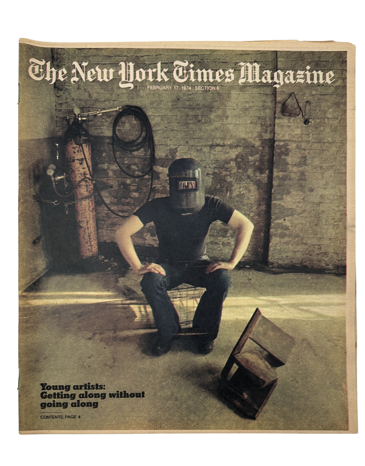 Cover of The New York Times Magazine dated February 17, 1974 featuring the title 'Young Artists: Getting along without going along,' showcasing a sculptor wearing a welder's mask seated in a dimly lit studio.