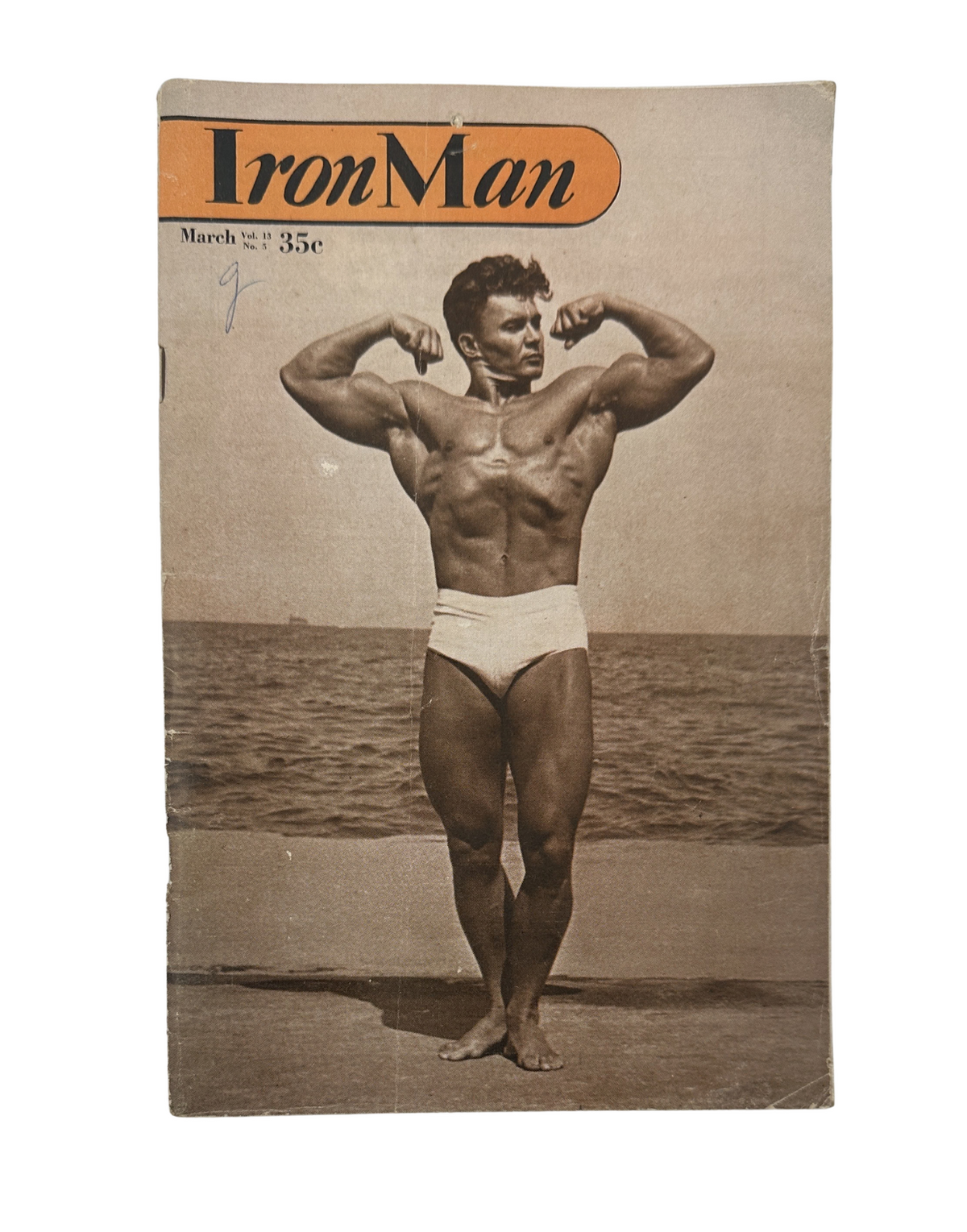 Cover of Iron Man Magazine March 1954 featuring Gene Bohaty showcasing a bodybuilding physique. The image captures Bohaty flexing his muscles at a beach.