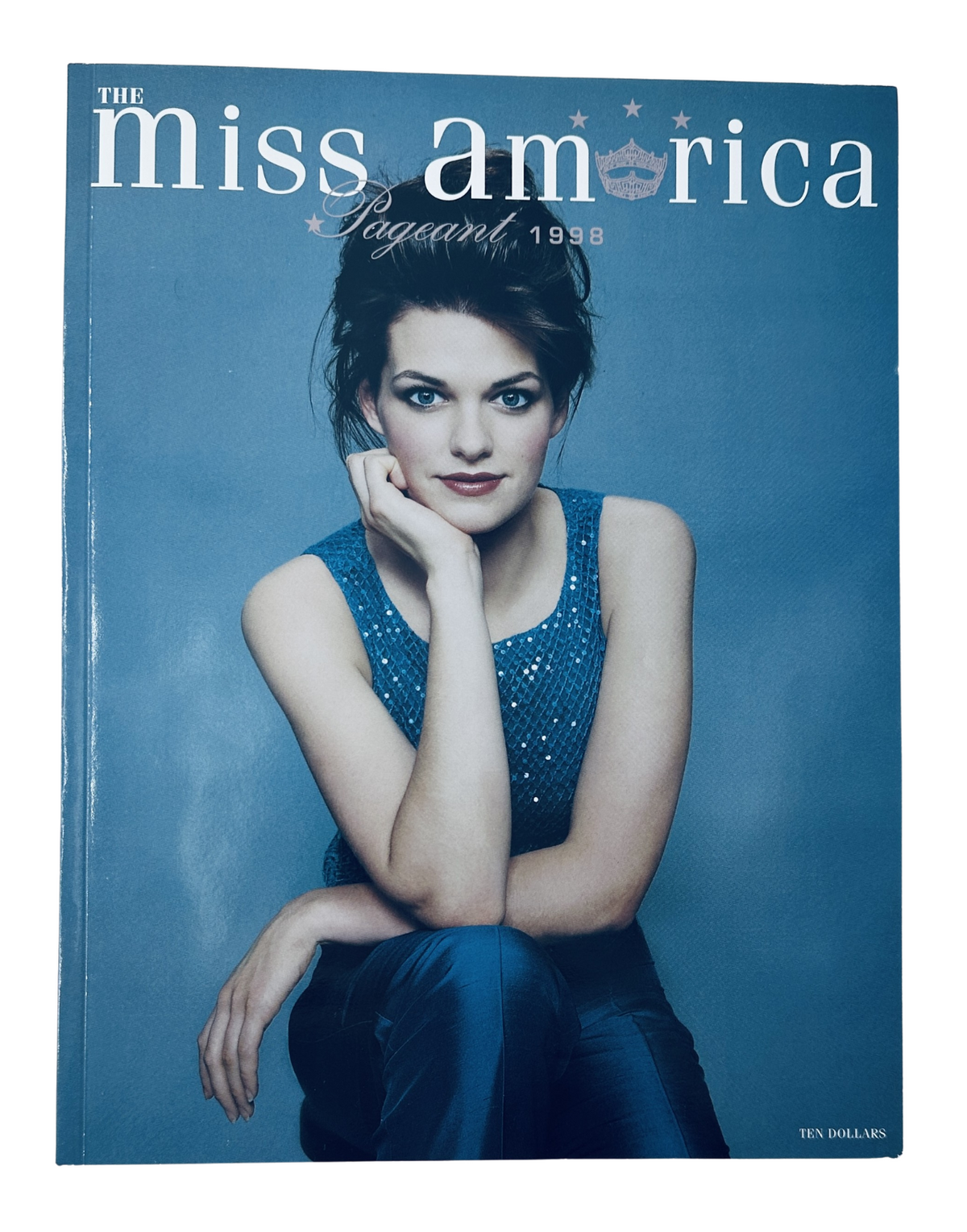 Cover of 'Miss America Pageant 1998' featuring a contestant, showcasing stylish attire and a clean blue background, representing the official program.