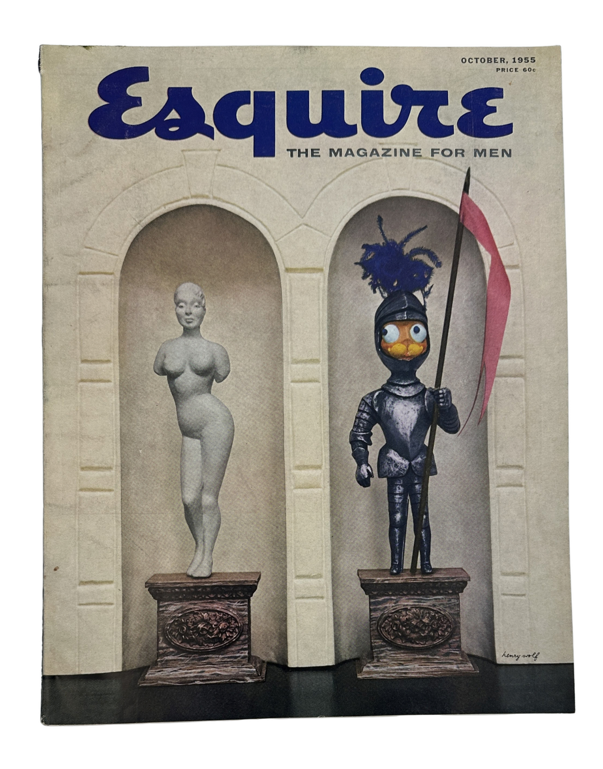 Cover of Esquire Magazine October 1955 featuring a whimsical display with a knight in armor holding a flag and a stylized sculpture of a nude female figure, highlighting the unique artistic style of the period.