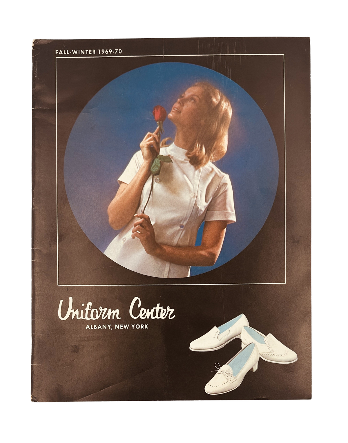 Cover of the Uniform Center Catalog Fall/Winter 1969-70 showcasing a model in a nurse uniform posing with a rose, featuring stylish medical footwear and highlighting the fashion of the era.