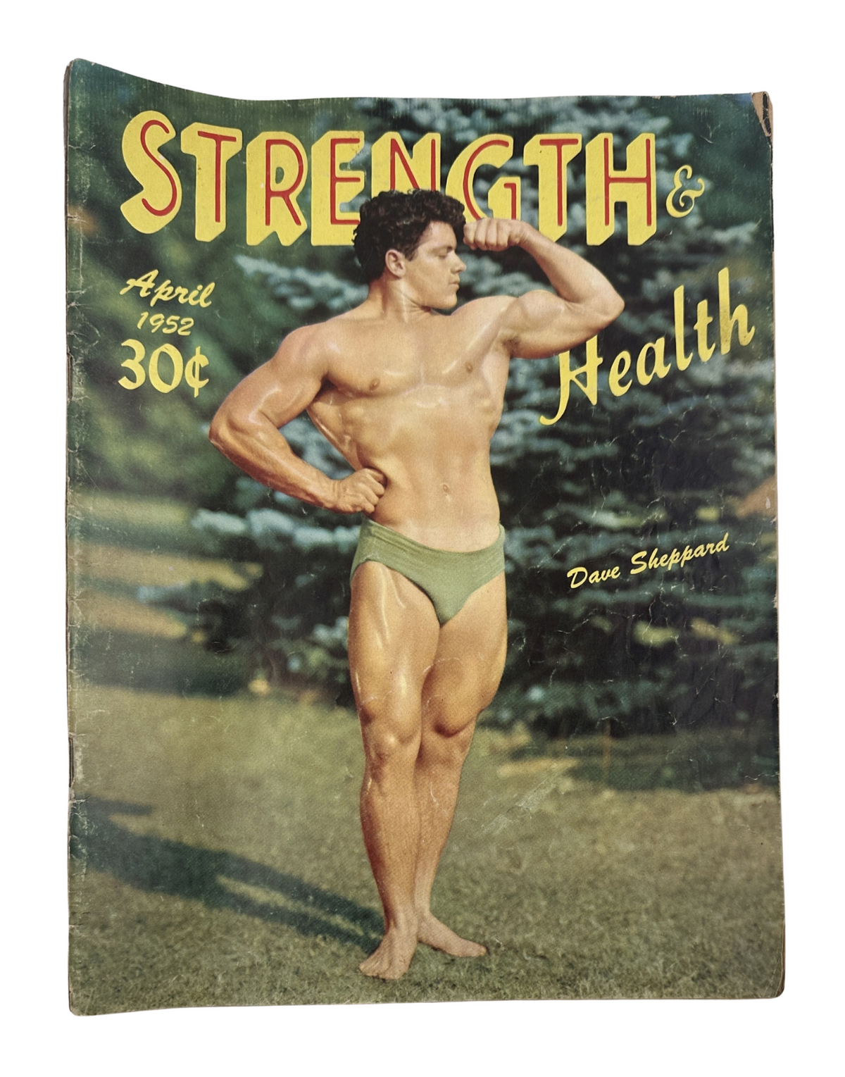 Strength and Health Magazine April 1952 cover featuring Dave Sheppard showcasing a muscular pose against a backdrop of pine trees.