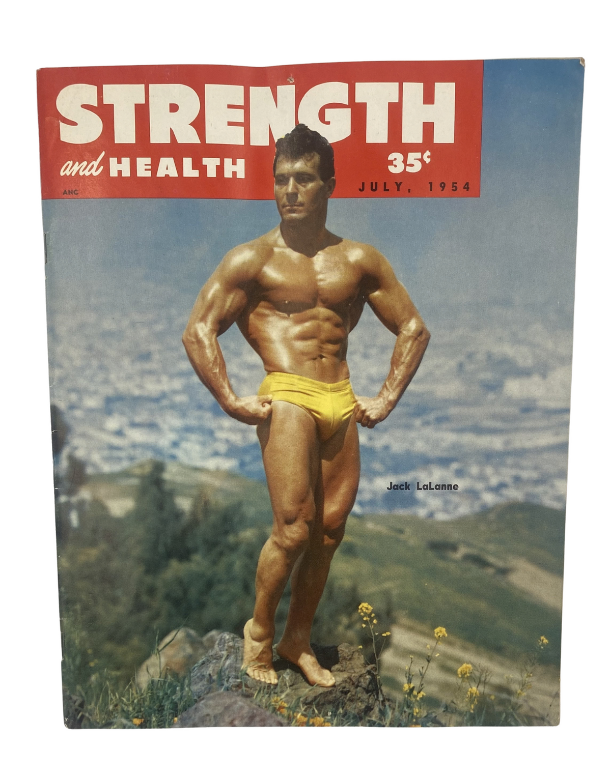 Strength and Health Magazine July 1954 featuring a muscular Jack LaLanne on the cover showcasing bodybuilding in a picturesque outdoor setting.