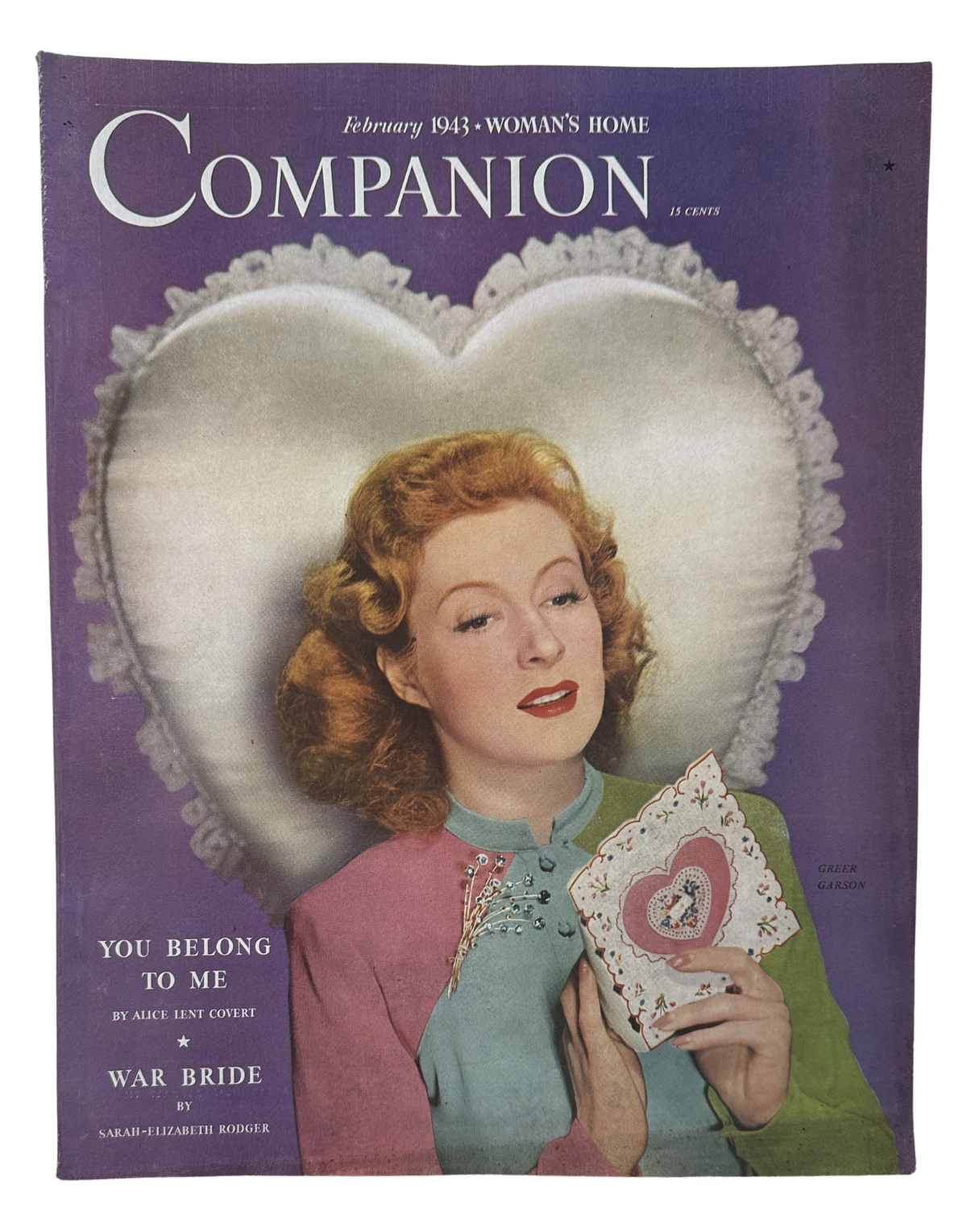 February 1943 Woman’s Home Companion Magazine featuring the War Bride cover and the title 'You Belong to Me' by Alice Lent Covert, showcasing a woman with red hair holding an illustrated card against a heart-shaped background.