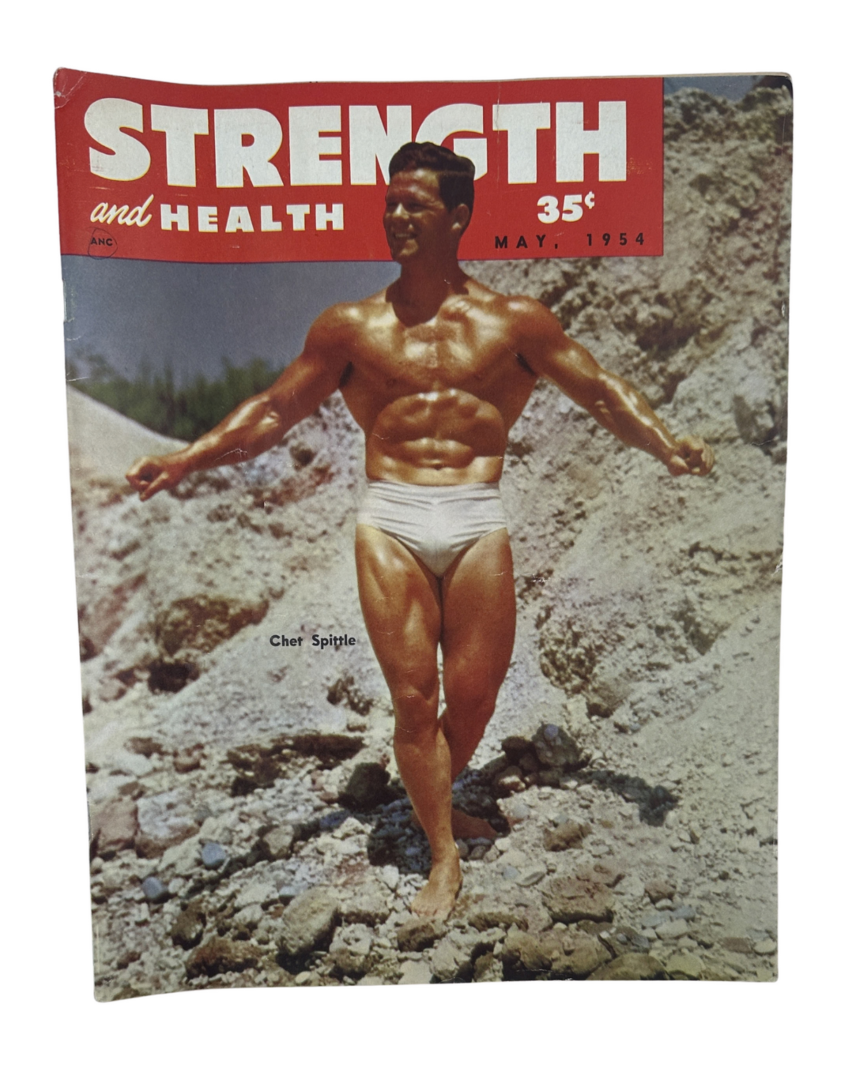 Strength and Health Magazine May 1954 featuring Chet Spittle on the cover, showcasing a muscular male figure posing in swimwear against a rocky backdrop, highlighting bodybuilding and fitness themes.