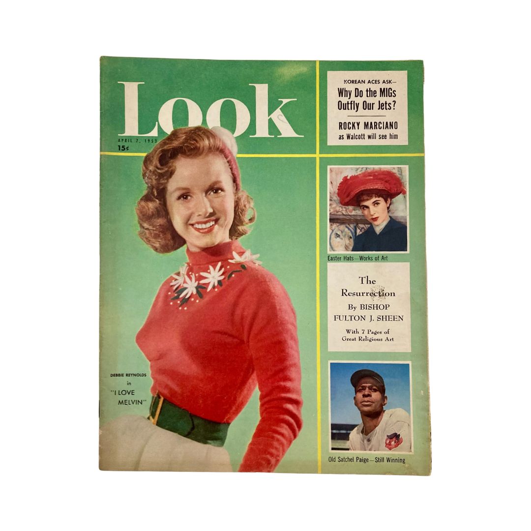 Cover of VTG Look Magazine from April 7, 1953, featuring a smiling woman in a red sweater with floral designs, alongside images of Easter hats and baseball player Satchel Paige. A collectible piece showcasing iconic personalities of the 1950s.