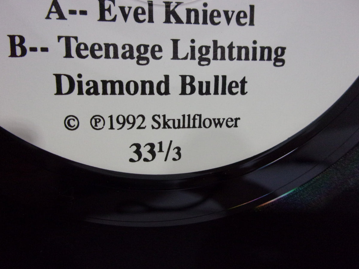 Detailed close-up of Skullflower: Evel Knievel SFTRI 202 7" single vinyl record label, including copyright information and track details.