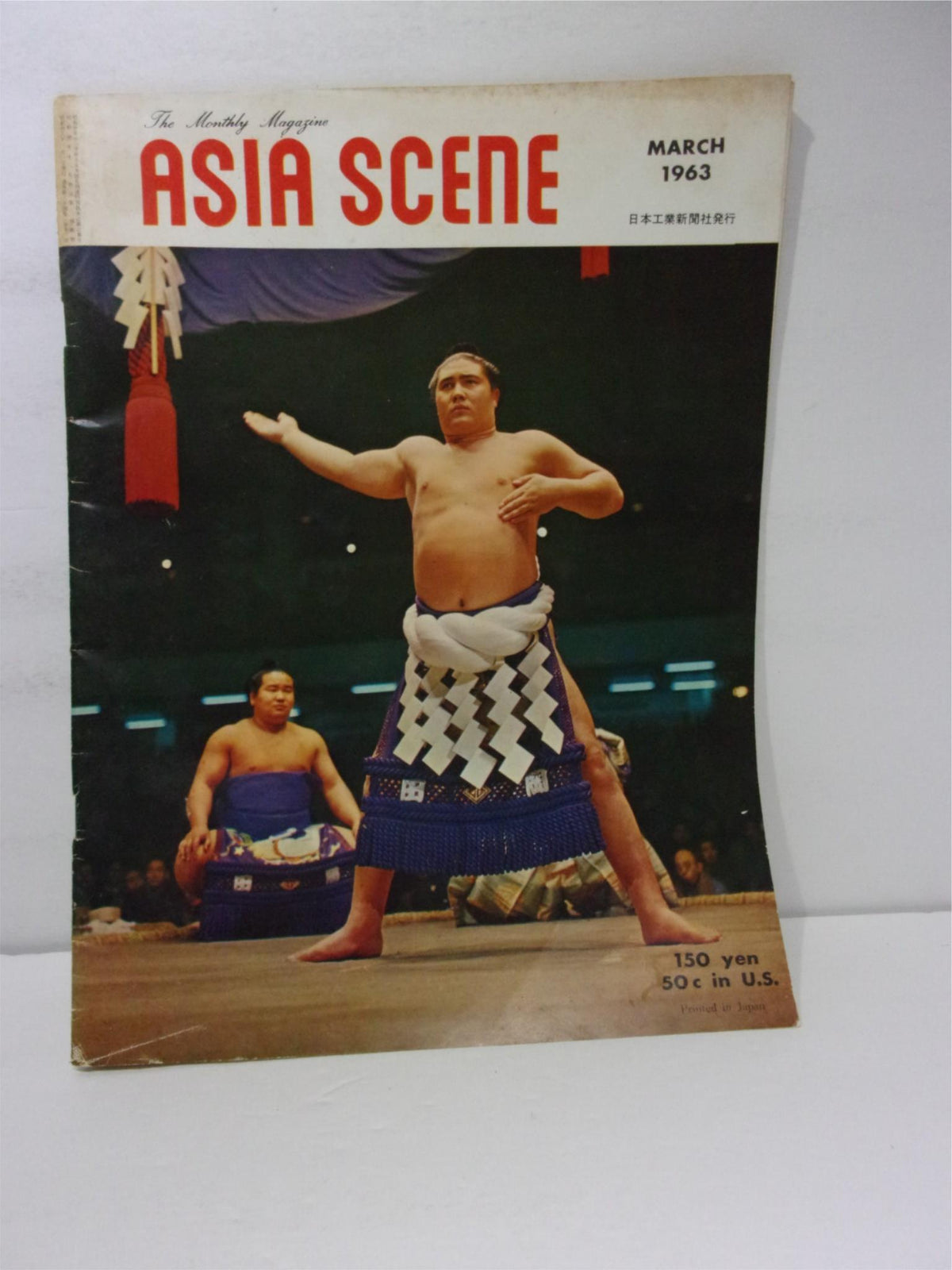 Cover of Asia Scene: The Monthly Magazine March 1963 featuring a sumo wrestler performing, highlighting vintage Asian culture.