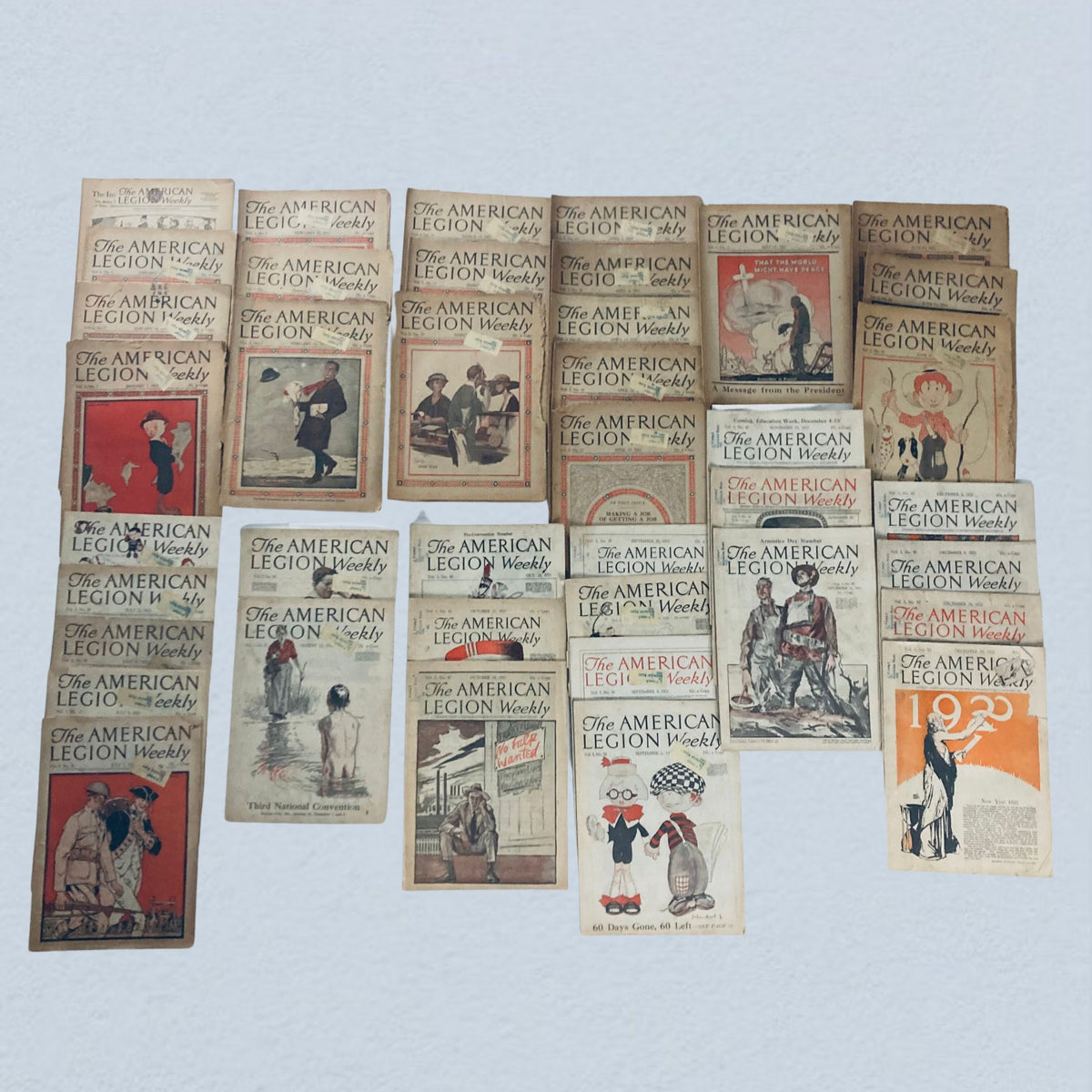 Lot of 40 vintage The American Legion Weekly Magazine issues from January and December 1921 showcasing distinctive covers and historical illustrations.