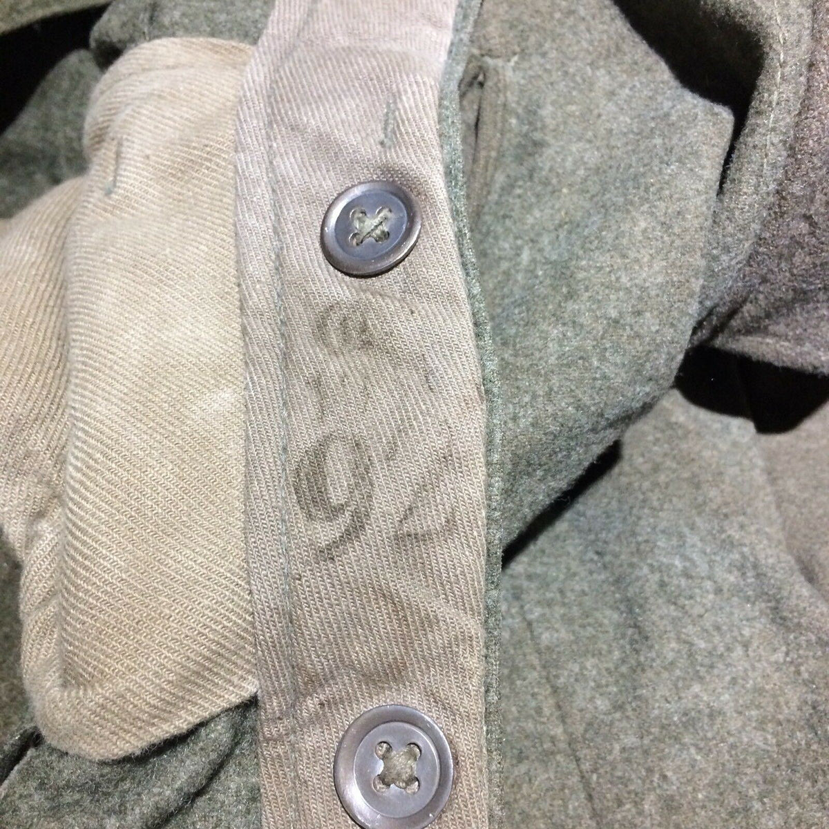 Interior lining of Vintage Swedish army military hunting cargo pants displaying buttons and label markings.