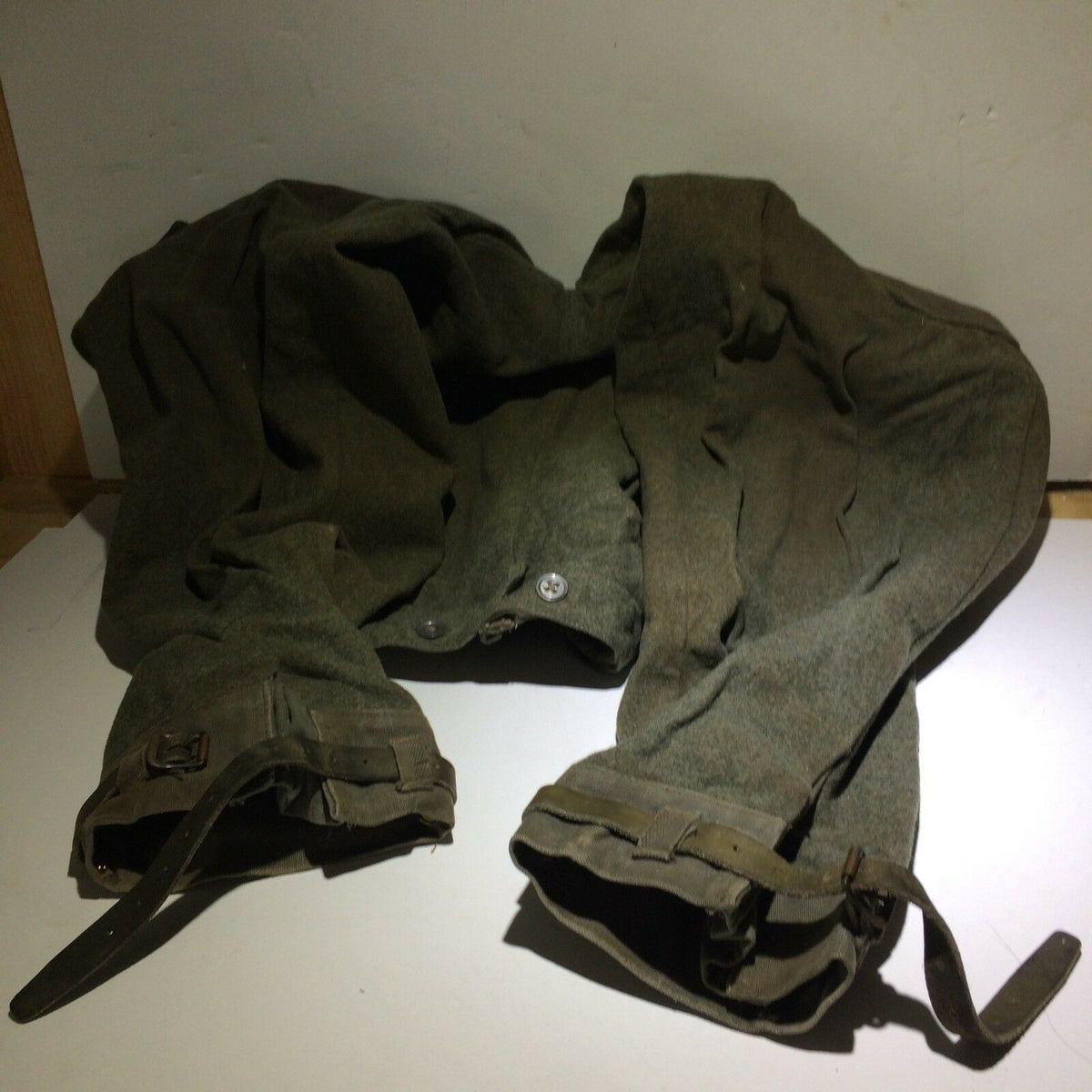 Vintage Swedish army military hunting cargo pants displayed flat, emphasizing the worn fabric and unique design features.