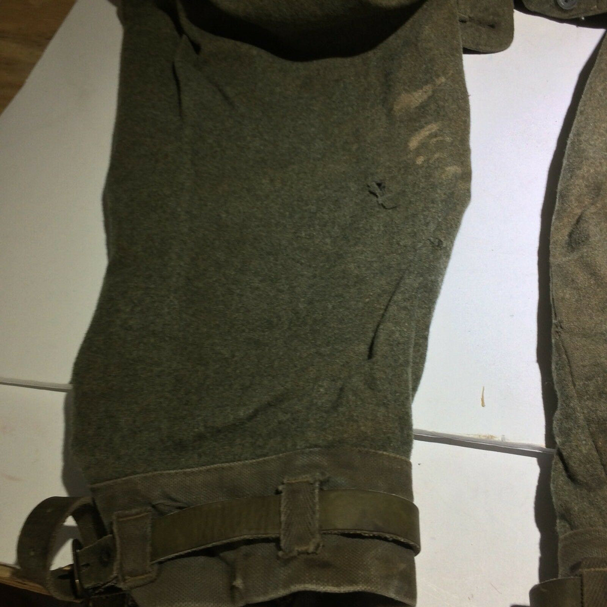 Detailed close-up of Vintage Swedish army military hunting cargo pants highlighting wear and tear on the fabric.