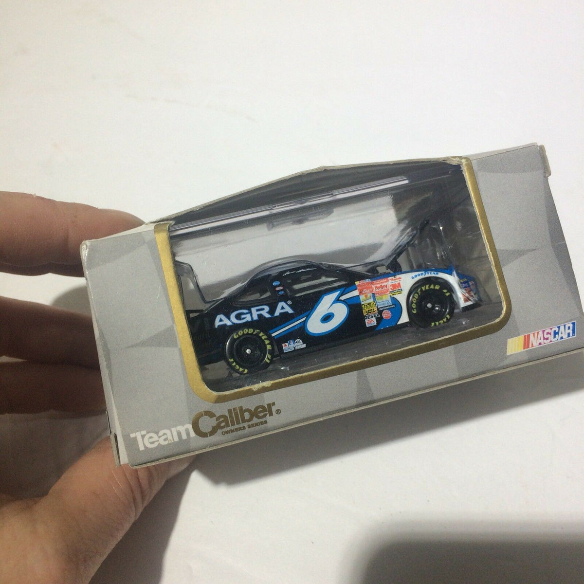 Side view of the Team Caliber 2003 Limited Edition Mark Martin #6 'Viagra' 1:64 Die-Cast model displayed inside the packaging, showcasing the car details and branding.