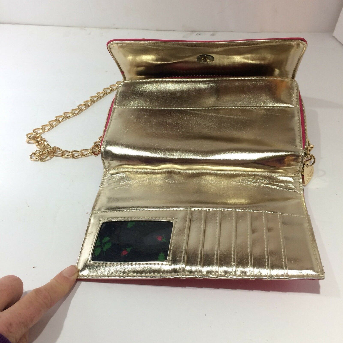Interior view of the Betsey Johnson Pink & Gold Chain Purse Bag Quilted Heart Lock Bow Lipstick, highlighting the shiny gold lining and card slots.