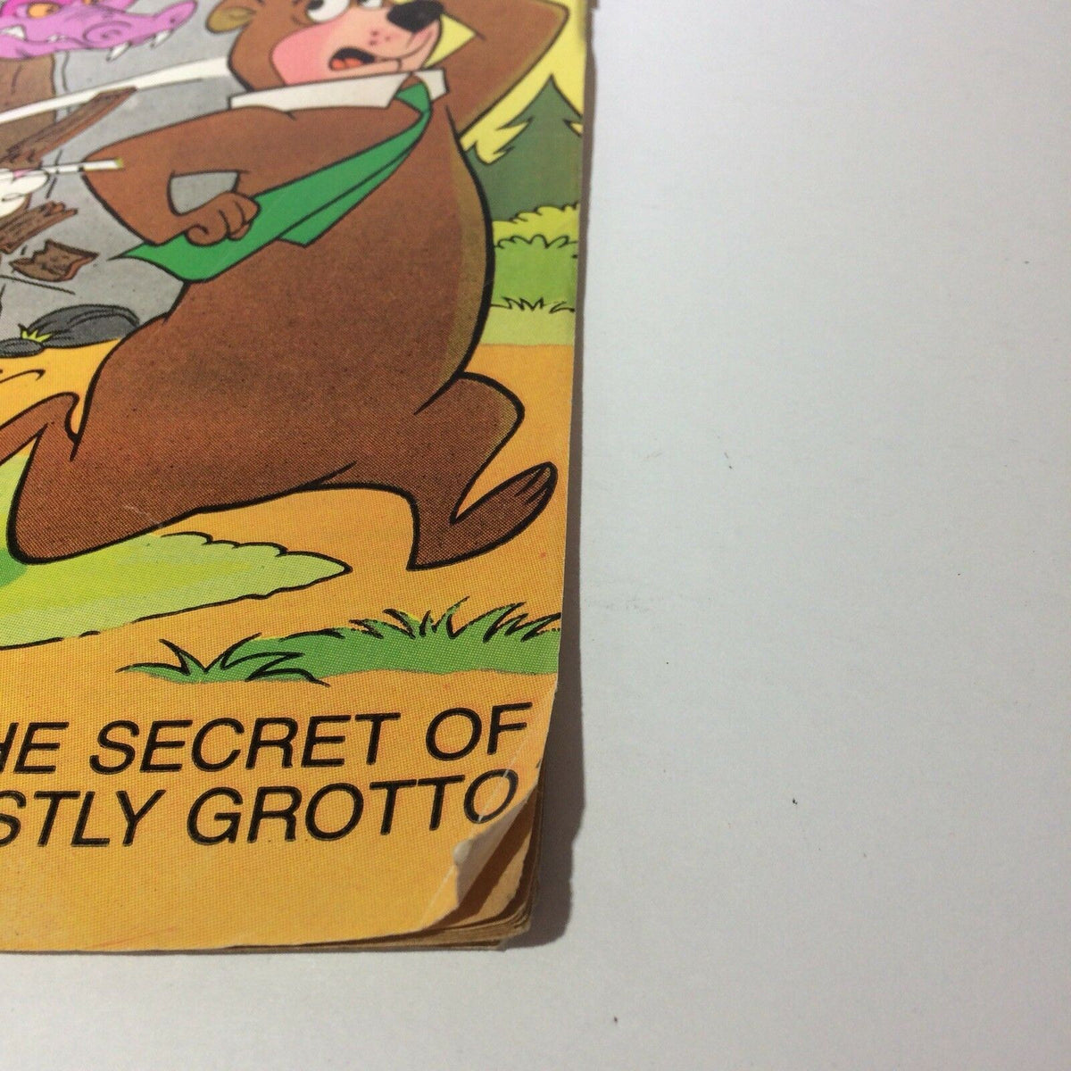 Detail of the corner of Marvel Comics YOGI BEAR #1 cover, showcasing a slight bend and the title 'The Secret of Ghastly Grotto'.