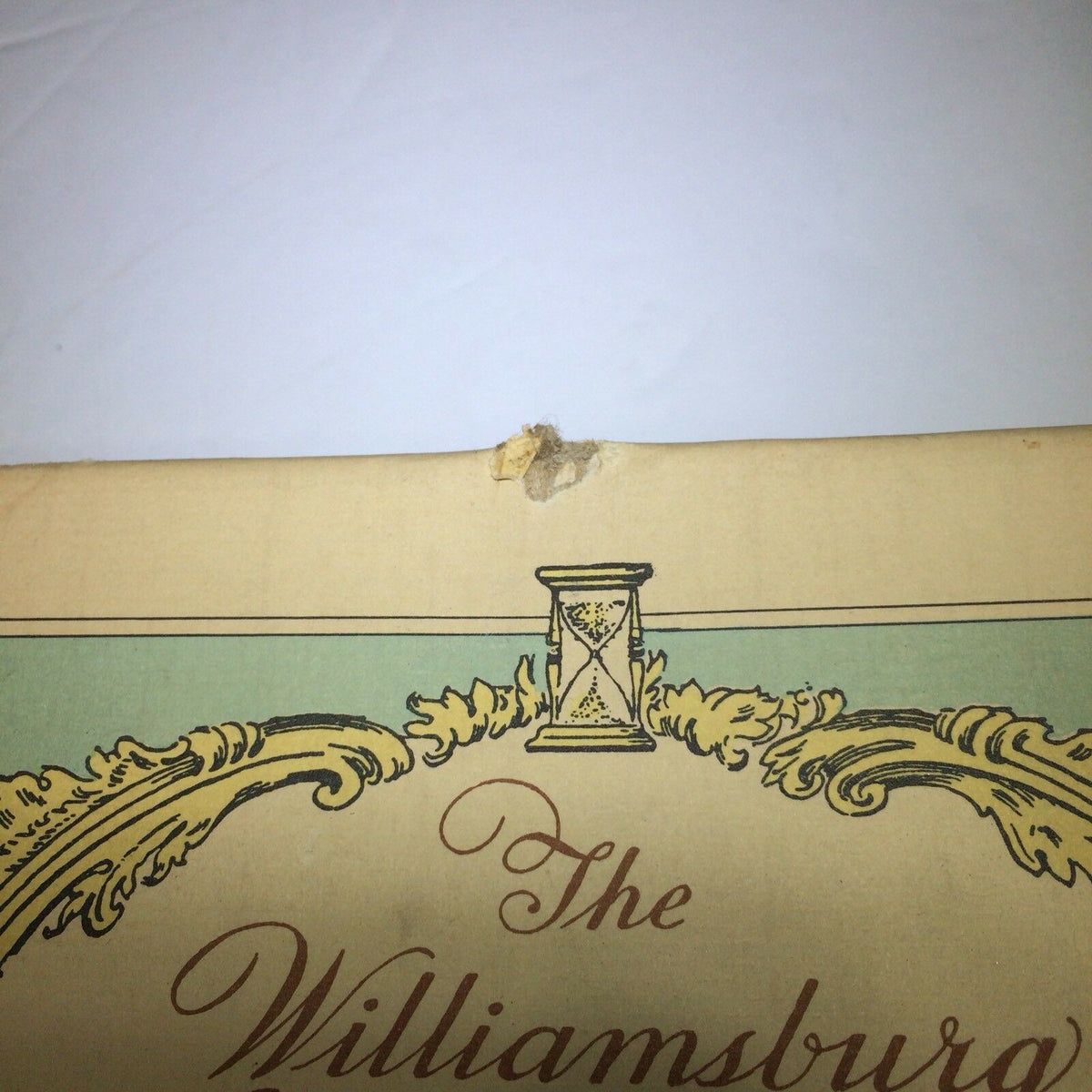 Close-up view of the top edge of the Vintage 1976 Williamsburg Calendar & Almanack, showing minor wear and a small damage near the title area.