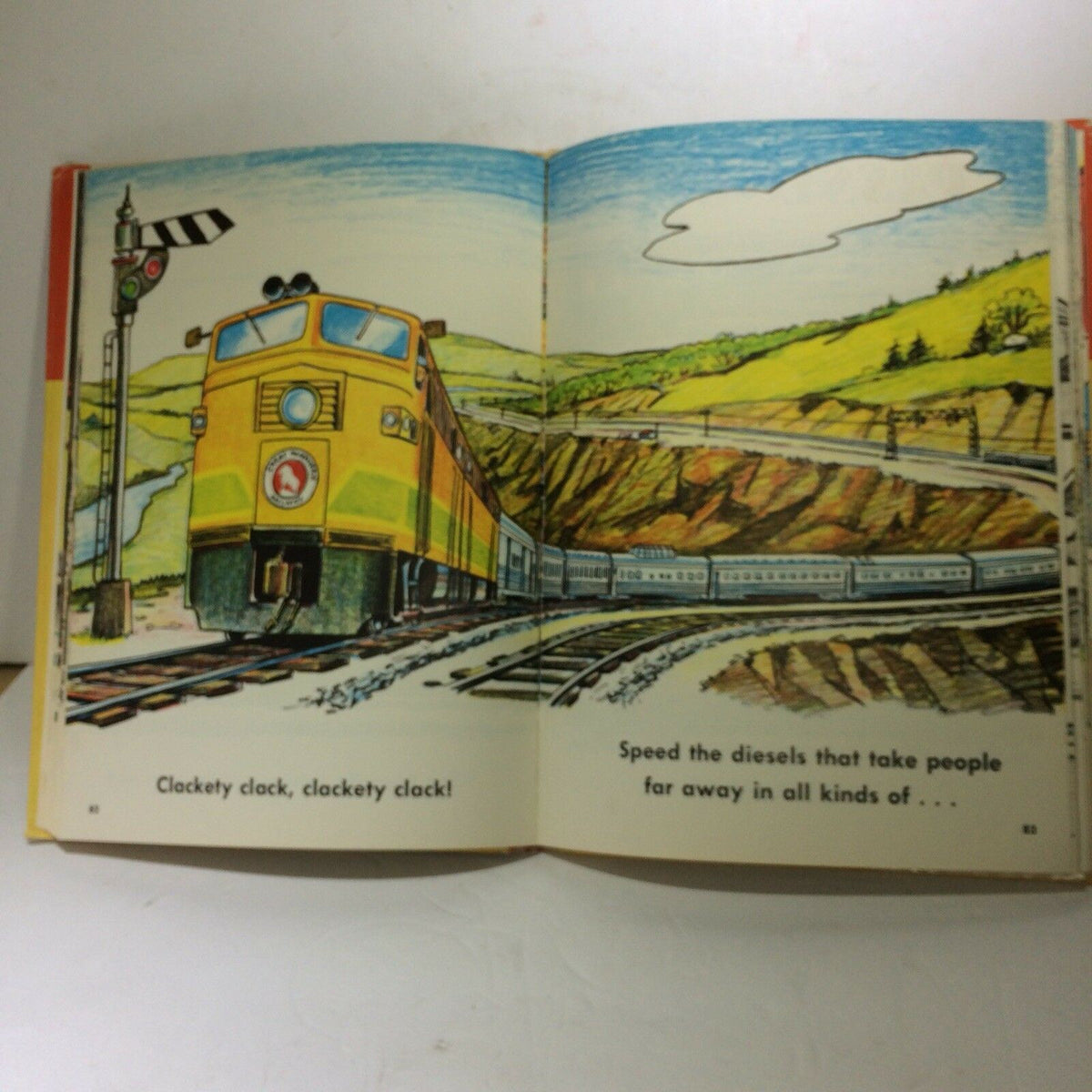 Illustrated page from The Giant Nursery Book of Things That Go by George Zaffo depicting a vibrant yellow train traveling through a scenic landscape.