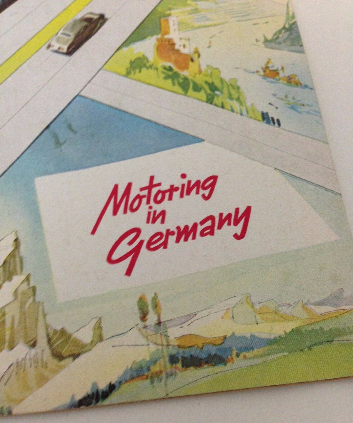 Close-up of the Vintage 1950s Guide Booklet to Motoring in Germany cover highlighting the title with artistic design elements.