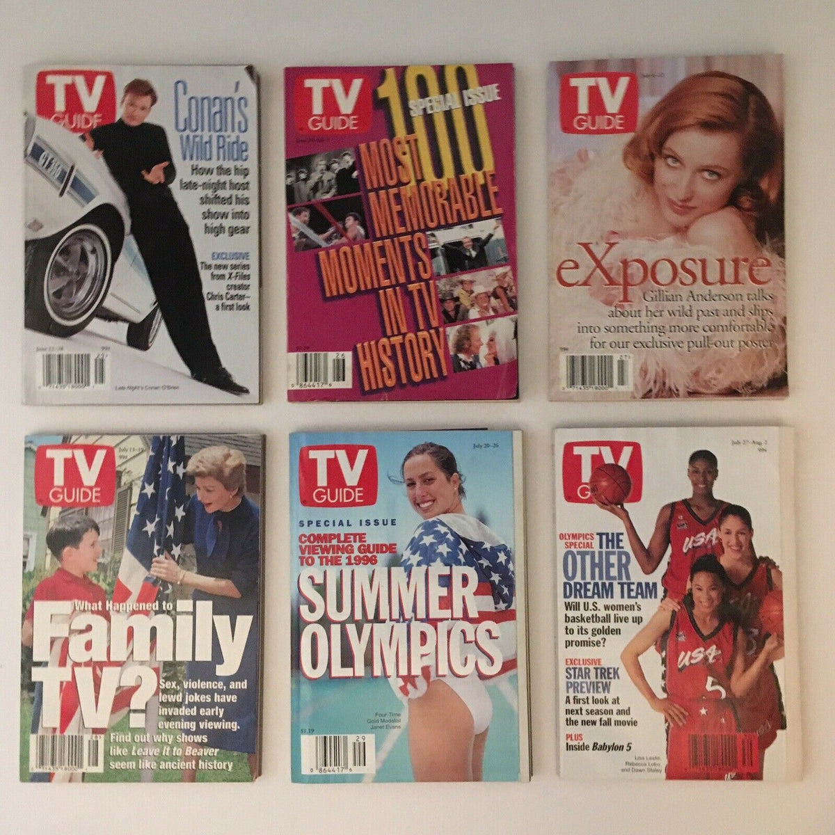 Row of TV Guide magazines from 1996, showcasing special issues on memorable TV moments and the Summer Olympics, emphasizing historical events in television.