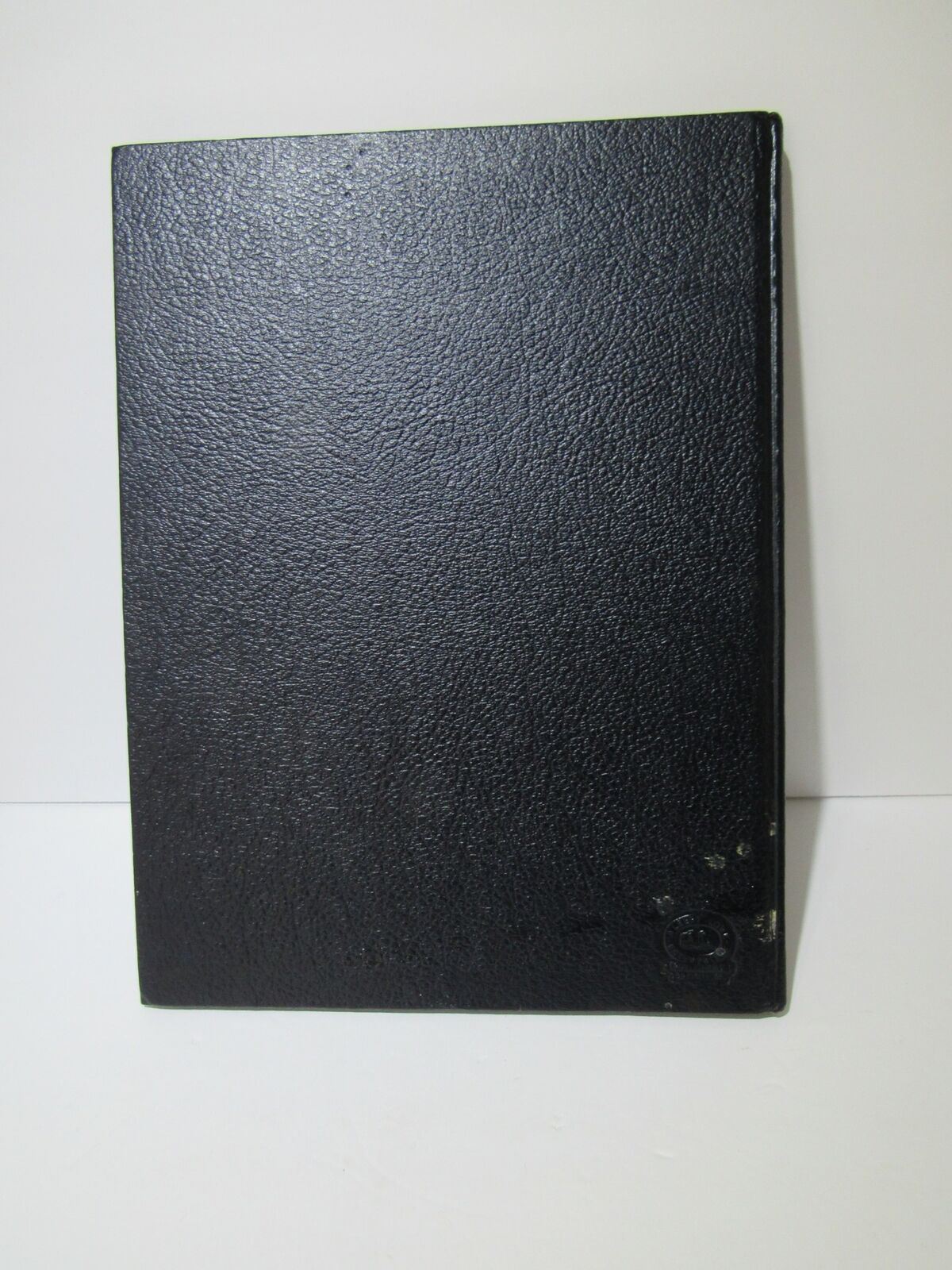 Close-up view of the cover of the Vintage 1966 Keel United States Naval Training Center Company 1, featuring a black textured surface.