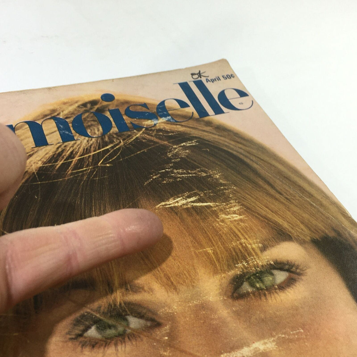 Detail of the VTG Mademoiselle Magazine: April 1967 College Beauty Fashion Issue revealing the magazine's cover wear and texture.