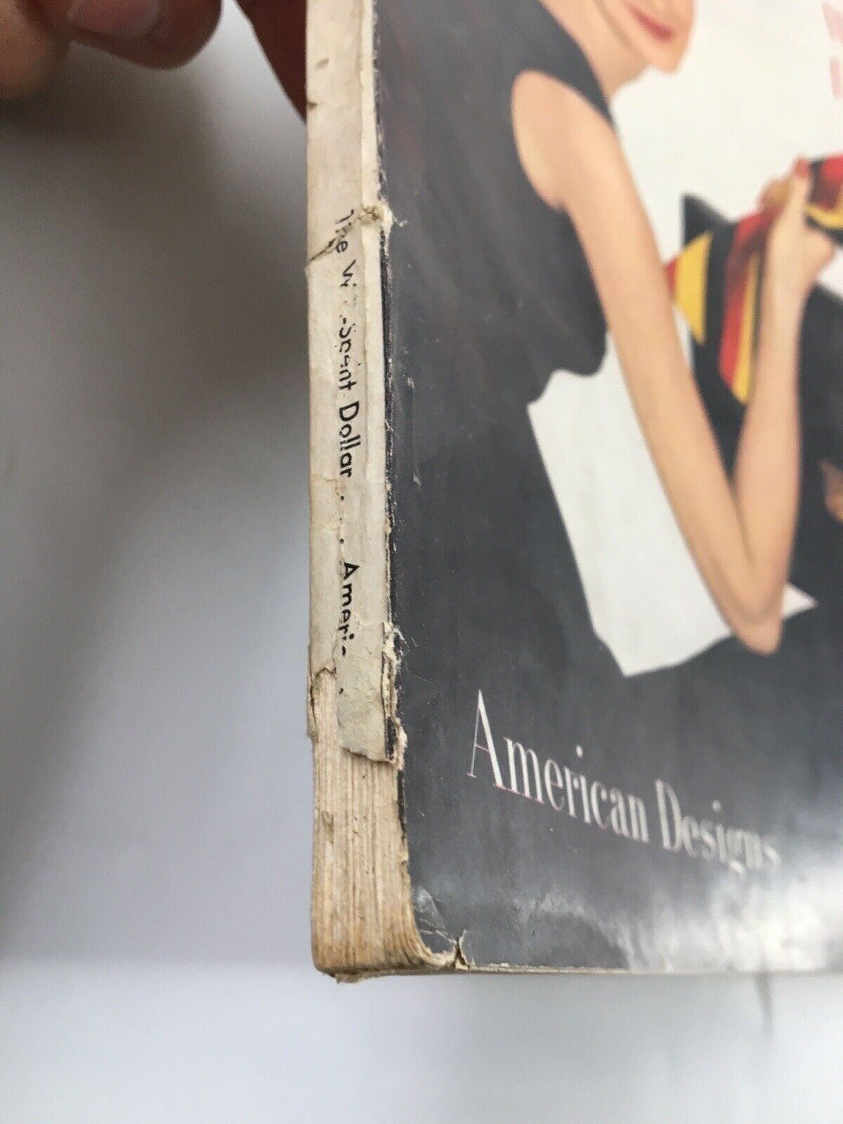 Side view of Harper's Bazaar Magazine February 1953 showing wear on the spine and details of the cover design, emphasizing its vintage authenticity.