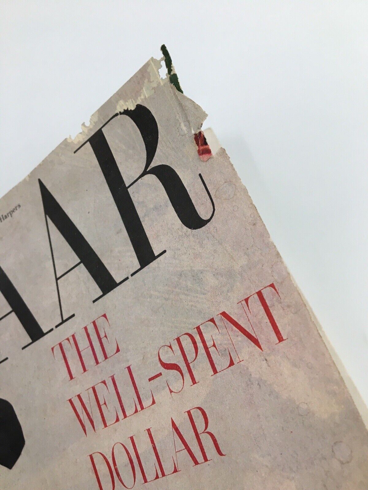 Upper corner detail of Harper's Bazaar Magazine February 1953 revealing vintage cover wear and the title text, representing the era's fashion journalism.