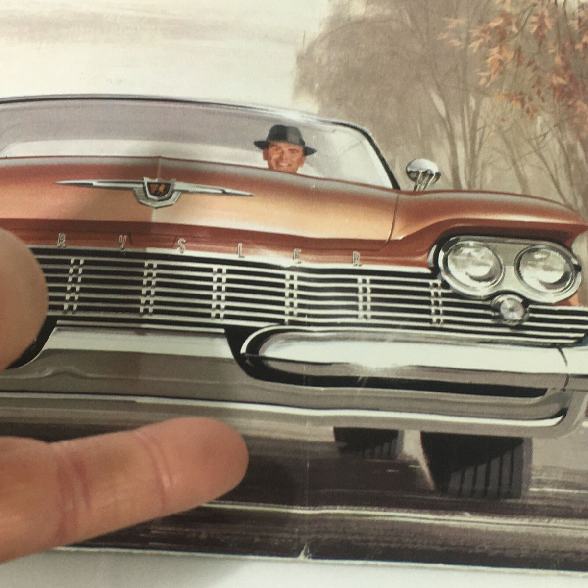 Illustration of the VTG 1959 Chrysler Windsor New Yorker Sedan Hardtop featuring a driver and the vehicle's front view from the VTG 1959 Chrysler Windsor New Yorker Sedan Hardtop Car Auto Brochure Catalog.