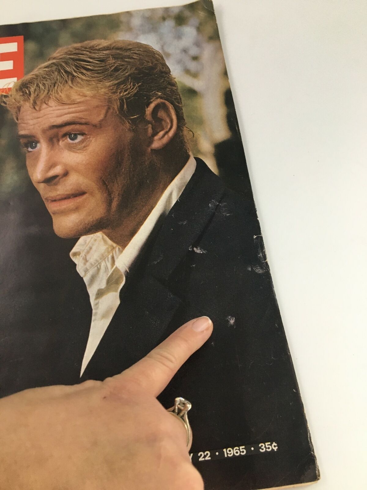 Close-up view of Vintage Life Magazine cover dated January 22, 1965, highlighting actor Peter O'Toole, with hand pointing to minor wear and details on the cover.