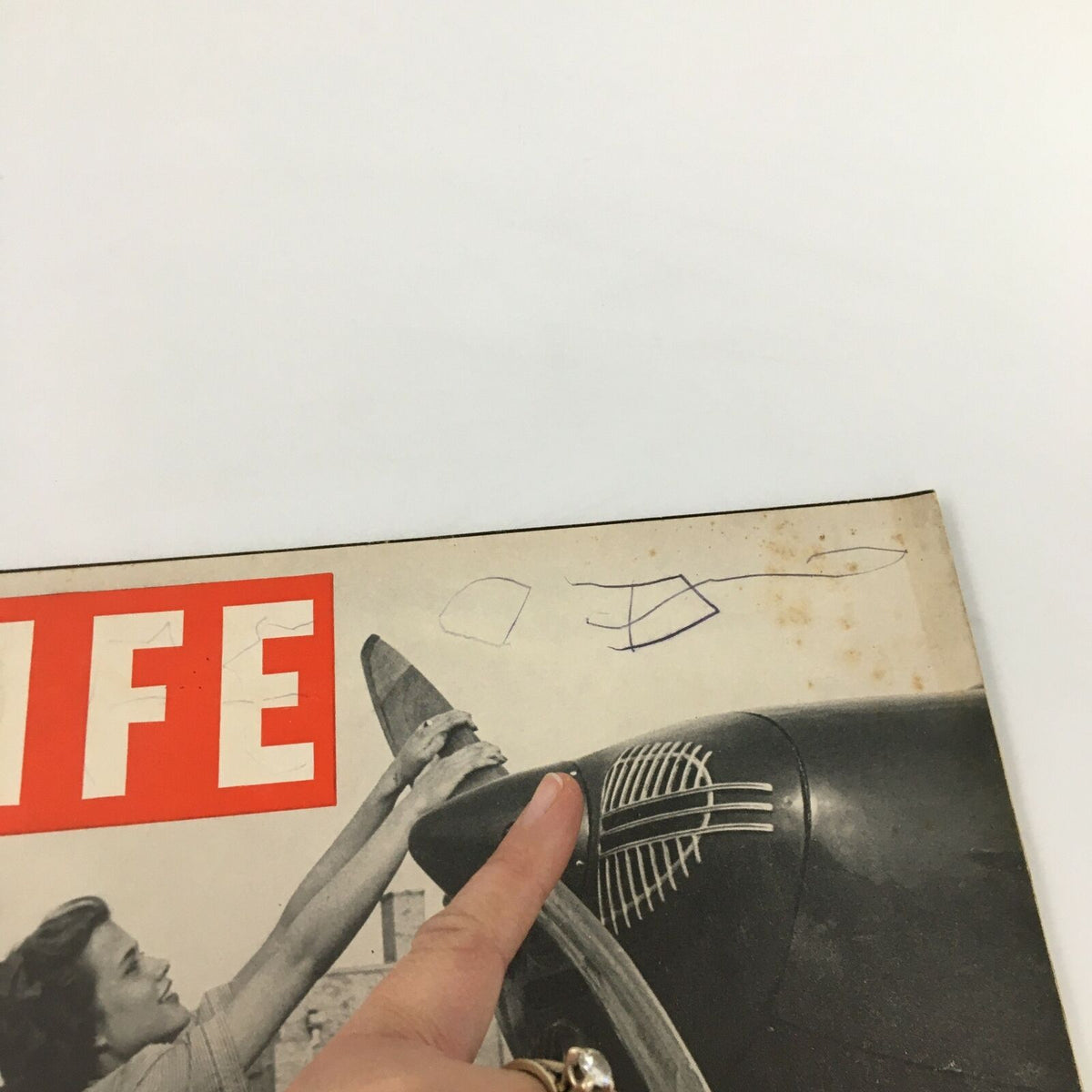 Close-up of the top section of the VTG Life Magazine cover from September 16, 1940, highlighting the phrase 'Flight Across America' and a woman's hand touching the airplane propeller.