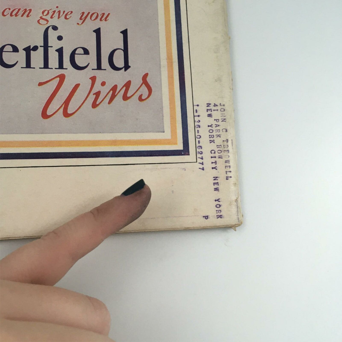 Close-up of the bottom corner of VTG Life Magazine March 22, 1937, showcasing the magazine's spine with a finger pointing at the text, highlighting details of the advertisement and publication information.