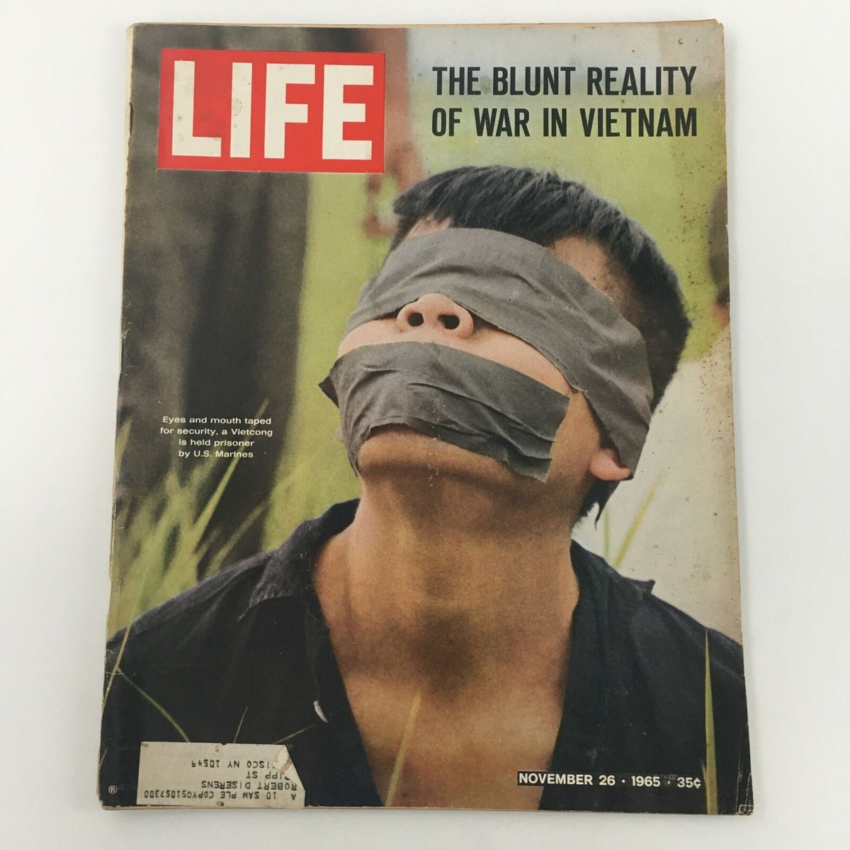 Cover of VTG Life Magazine, November 26, 1965, featuring a haunting image of a Vietcong prisoner with eyes and mouth taped, highlighting the blunt reality of war in Vietnam.