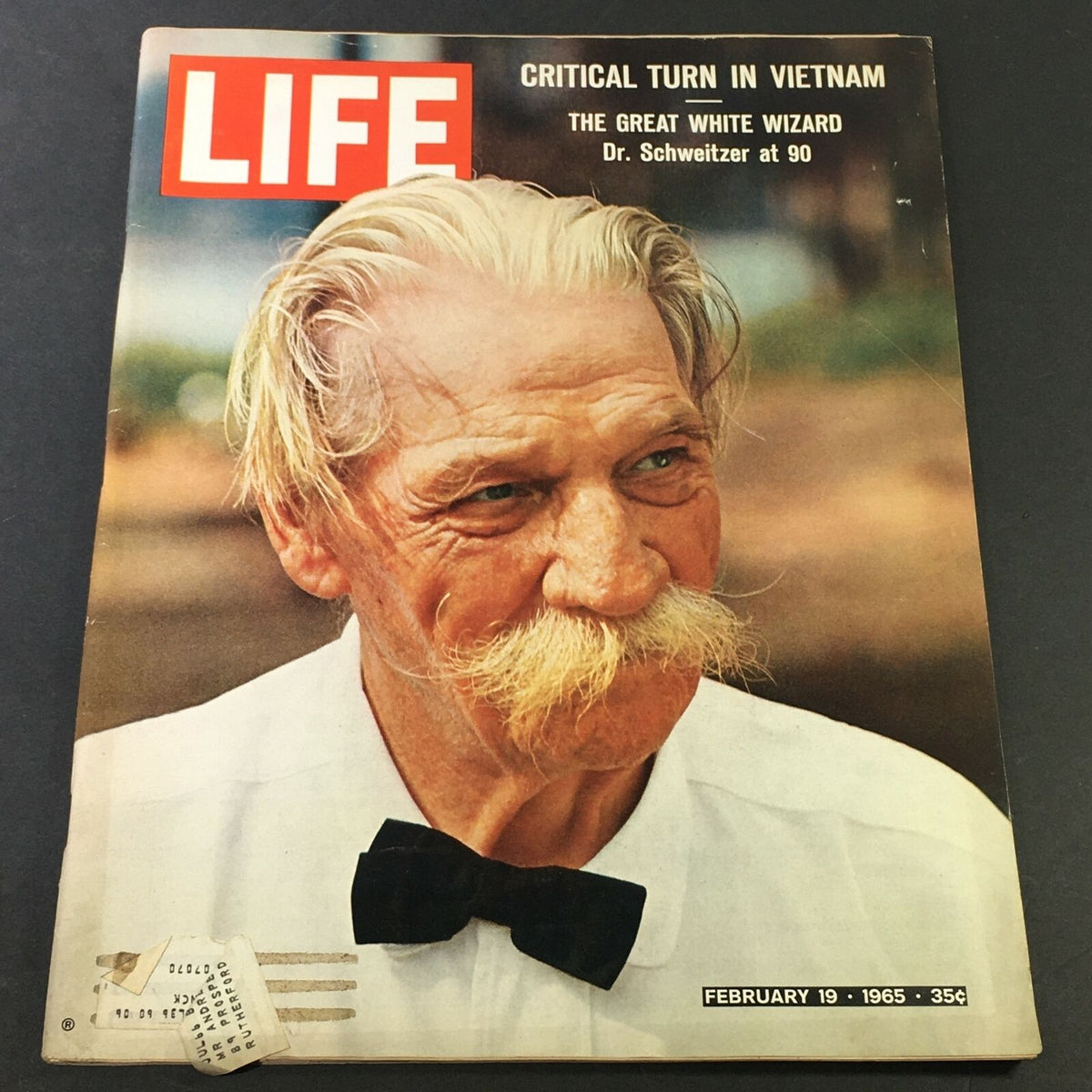 Vintage Life Magazine cover from February 19, 1965, featuring Dr. Albert Schweitzer, known as the Great White Wizard, showcasing his thoughtful expression with a backdrop highlighting the era's cultural significance.