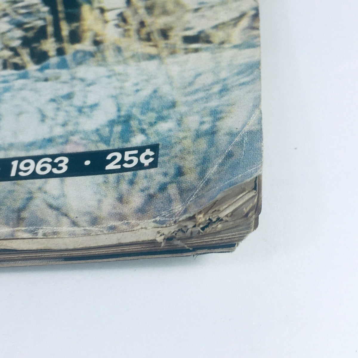 Close-up of the bottom edge of the VTG Life Magazine April 12 1963, highlighting the vintage appeal with the publication year 1963 and a price of 25 cents, along with visible wear on the edge.