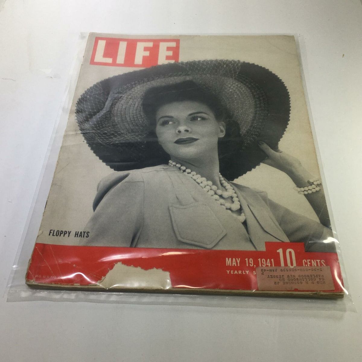 Cover of the May 19, 1941 issue of Life Magazine featuring a woman wearing a floppy hat. The magazine highlights the topic 'Floppy Hats' and is presented in a protective plastic covering, showcasing its vintage appeal.